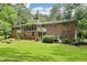 Scenic backyard view with brick house, screened porch and mature trees at 415 Haven Ln, Marietta, GA 30066