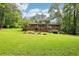 Sprawling backyard with a brick house, deck, and lush greenery at 415 Haven Ln, Marietta, GA 30066