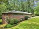 Brick home featuring manicured landscaping, green shutters, and mature foliage around the foundation at 415 Haven Ln, Marietta, GA 30066