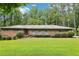 Charming one-story brick home with a lush green lawn and mature trees creating a serene setting at 415 Haven Ln, Marietta, GA 30066