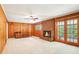Bright and open living room with wood paneling, brick fireplace, and glass doors to the backyard at 415 Haven Ln, Marietta, GA 30066