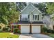 Charming two-story home with a brick-and-green facade, attached garage, and well-maintained landscaping at 4284 Cabretta Se Dr, Smyrna, GA 30080