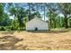 Back of a modern home with a large, empty backyard surrounded by lush green trees at 124 Sims Dr, Hiram, GA 30141