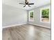 Bright bedroom with hardwood floors, ceiling fan, and two windows with scenic outdoor views at 124 Sims Dr, Hiram, GA 30141