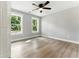Well-lit bedroom with hardwood floors, ceiling fan, and two windows offering views of the outdoors at 124 Sims Dr, Hiram, GA 30141