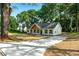 Inviting one-story home with new concrete driveway, board and batten siding, and mature trees at 124 Sims Dr, Hiram, GA 30141