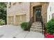 Close-up of home's entrance with stone steps leading to a dark wood door and attached two-car garage at 189 Privet Cir, Suwanee, GA 30024