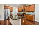 A kitchen features a large central island, wooden cabinetry, granite countertops, and stainless steel appliances at 189 Privet Cir, Suwanee, GA 30024
