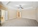 Neutral-colored main bedroom features a tray ceiling, fan, and access to ensuite bathroom at 189 Privet Cir, Suwanee, GA 30024