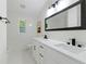 Bright bathroom featuring double vanity, modern fixtures, and large framed mirror at 2349 Echo Cliff Ne Ct, Atlanta, GA 30345
