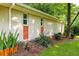 Side view of a home with light brick, orange accents, well maintained landscaping, and mature tree at 2349 Echo Cliff Ne Ct, Atlanta, GA 30345
