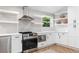 Well-lit kitchen with stainless steel appliances, floating shelves, and white cabinetry at 2349 Echo Cliff Ne Ct, Atlanta, GA 30345