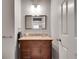 Elegant half bathroom featuring a wooden vanity with a stone countertop at 255 Wembley Cir, Atlanta, GA 30328