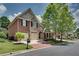 Charming brick home with a two-car garage, complemented by a lush green lawn and mature trees at 255 Wembley Cir, Atlanta, GA 30328