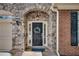 Inviting front entrance with stone archway, elegant wreath, sidelights, and stone tile floor at 255 Wembley Cir, Atlanta, GA 30328