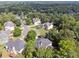 An aerial perspective reveals houses nestled within a lush landscape of mature trees at 302 Shawnee Indian Ln, Suwanee, GA 30024