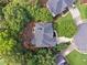 Birds eye view of home's roof, surrounding mature trees, with driveway and manicured yard at 302 Shawnee Indian Ln, Suwanee, GA 30024