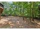 Spacious backyard with mature trees and partially fenced area at 302 Shawnee Indian Ln, Suwanee, GA 30024