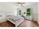 Bright bedroom with wood floors, a white paneled accent wall, and a window overlooking the yard at 302 Shawnee Indian Ln, Suwanee, GA 30024