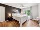 A well-lit bedroom featuring wood floors, a dark accent wall, and a ceiling fan at 302 Shawnee Indian Ln, Suwanee, GA 30024