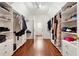 A long walk-in closet with custom shelving and wood floors offers ample storage space at 302 Shawnee Indian Ln, Suwanee, GA 30024