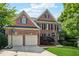 Charming two-story brick home with a two-car garage and a well-manicured front lawn at 302 Shawnee Indian Ln, Suwanee, GA 30024