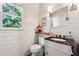 Charming powder room with shiplap walls, modern fixtures, and a decorative mirror at 302 Shawnee Indian Ln, Suwanee, GA 30024