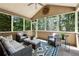 Screened porch with ceiling fan, comfortable seating, and a view of the wooded back yard at 302 Shawnee Indian Ln, Suwanee, GA 30024