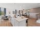 Open concept kitchen features island with seating, stainless appliances, and an adjacent dining area at 332 Heavenly Hollow Pl, Mcdonough, GA 30253