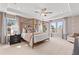 Well-lit main bedroom featuring a four-poster bed, tray ceiling, and a calming color palette creating a peaceful retreat at 332 Heavenly Hollow Pl, Mcdonough, GA 30253
