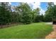Extensive backyard featuring a spacious lawn, a wooden fence, and mature trees for privacy and natural beauty at 3600 Morishop Nw Cv, Marietta, GA 30064