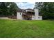 Spacious backyard showcasing the home's exterior, featuring a covered deck, a large yard and surrounding greenery at 3600 Morishop Nw Cv, Marietta, GA 30064