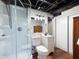 Bathroom with glass shower, white vanity, toilet, and wood-look flooring at 3600 Morishop Nw Cv, Marietta, GA 30064