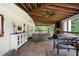 Covered back patio with cooking area, sitting area, and woodland views at 3600 Morishop Nw Cv, Marietta, GA 30064