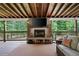 Covered back patio with fireplace, TV, and woodland views at 3600 Morishop Nw Cv, Marietta, GA 30064