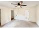 Spacious bedroom with neutral carpet, ceiling fan, and two entry doors at 4411 Flakes Mill Rd, Ellenwood, GA 30294