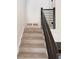 Carpeted stairs with modern railing lead to the upper level of this beautiful home at 4411 Flakes Mill Rd, Ellenwood, GA 30294