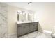 Stylish bathroom with a double vanity, marble floors and wall tiles, and modern lighting fixtures at 2331 Luther St, Lithonia, GA 30058