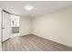 A serene bedroom with sleek, gray wood floors, neutral walls, and an open door to the bathroom at 2331 Luther St, Lithonia, GA 30058