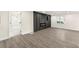 Spacious living room with gray floors, electric fireplace, access to bathroom and plenty of light at 2331 Luther St, Lithonia, GA 30058
