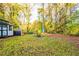 Large backyard with a storage shed, fire pit and mature trees creating a private outdoor space at 3182 Latona Sw Dr, Atlanta, GA 30354