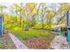 Spacious backyard featuring lush greenery, mature trees, and a brick pathway leading to outdoor seating areas at 3182 Latona Sw Dr, Atlanta, GA 30354