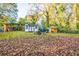 Large backyard with a storage shed, fire pit and mature trees creating a private outdoor space at 3182 Latona Sw Dr, Atlanta, GA 30354