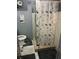 This bathroom boasts a sleek glass-enclosed shower with decorative curtain and neutral tile at 3182 Latona Sw Dr, Atlanta, GA 30354