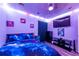 Vibrant bedroom with unique lighting, a flat-screen TV, dark furniture, and a cosmic-themed bedspread at 3182 Latona Sw Dr, Atlanta, GA 30354