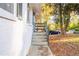 Side view of a painted white brick home with a gray staircase and matching shutters. A blue car sits in the background at 3182 Latona Sw Dr, Atlanta, GA 30354
