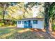 Charming single-story home with a white exterior, blue shutters, and a well-maintained front yard surrounded by mature trees at 3182 Latona Sw Dr, Atlanta, GA 30354