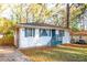 Charming one-story house with blue trim, white brick exterior and mature landscaping at 3182 Latona Sw Dr, Atlanta, GA 30354