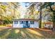 Charming single-story home featuring blue shutters, a covered front porch, and surrounded by mature trees at 3182 Latona Sw Dr, Atlanta, GA 30354
