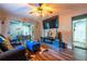 Comfortable living room featuring hardwood floors, a plush sofa, and a large TV above a modern fireplace unit at 3182 Latona Sw Dr, Atlanta, GA 30354